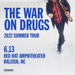 Cover photo with a man walking in snow with a coffee mug in one hand and a guitar in the other. Text reads: THE WAR ON DRUGS 2022 Summer Tour. 
