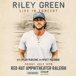 Cover Photo of Riley Green standing in front of a wood background wearing a grey hat and white short sleeve shirt. 