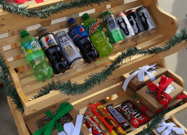 a photo of a snack cart with cookie boxes, sodas and chips
