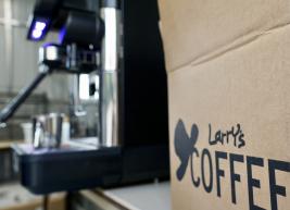 an unclose photo of Larrys coffee box and an espresso machine can be seen in the background