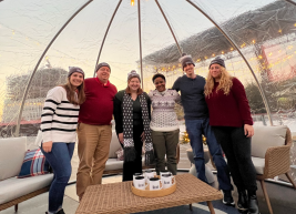 A group of people standing inside an igloo outside