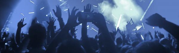 Concertgoers raising their hands and phones at a show at Red Hat Amphitheater in Raleigh, North Carolina